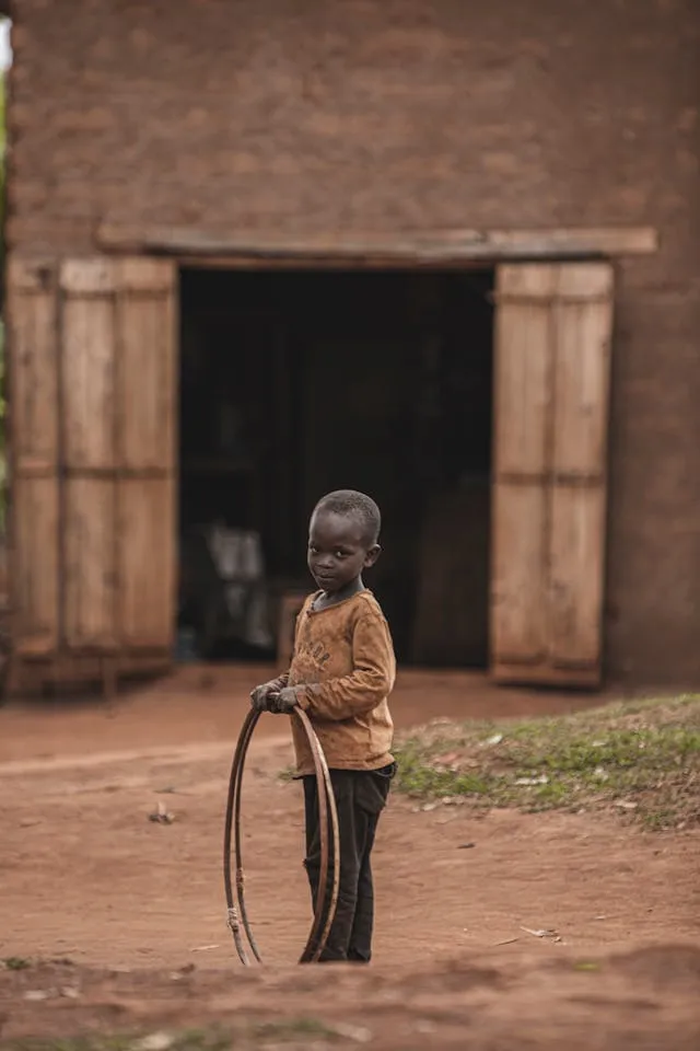 A child smiles warmly while playing outdoors, reflecting the stability and care that sponsorship provides